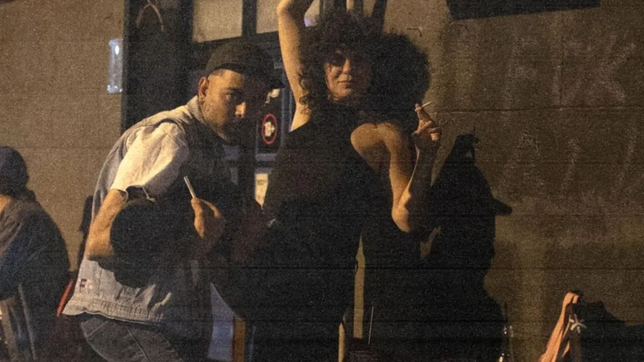 Dancing under the lit Komša sign, late night, grainy archive photo
